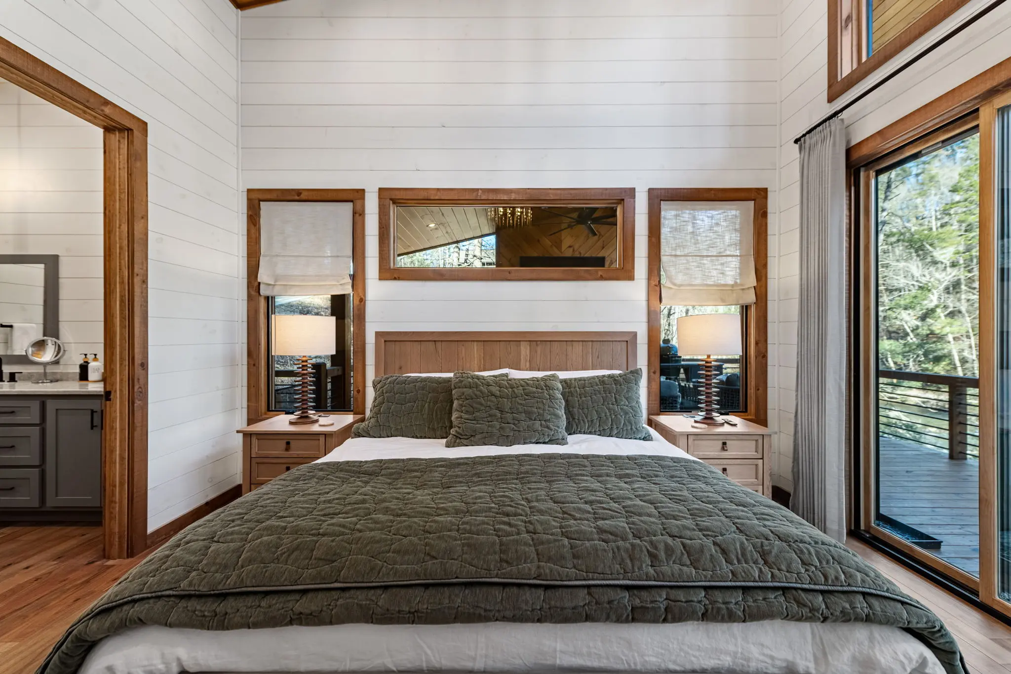 Luxurious primary bed with premium linens and creekside views.