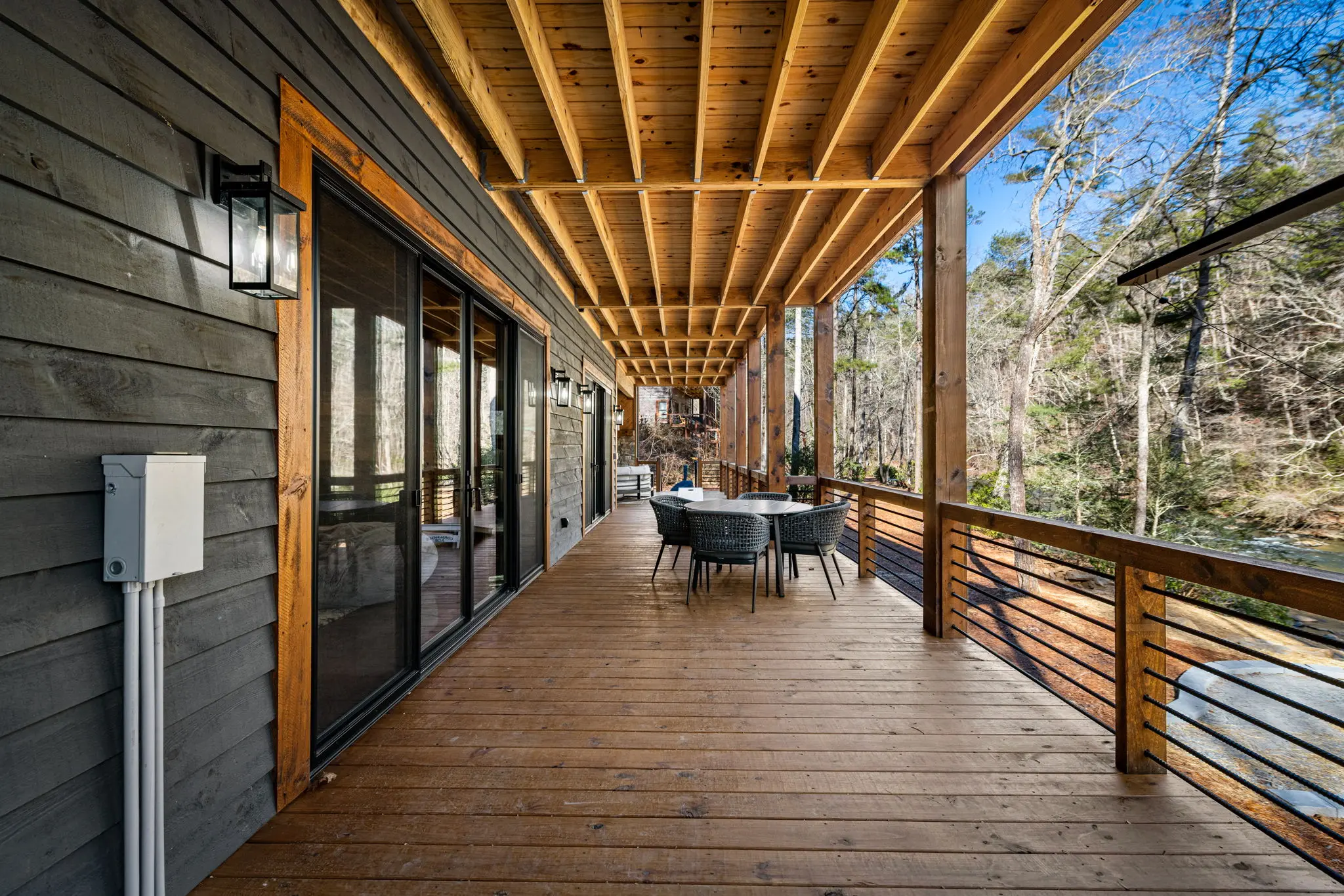 Covered lower-level balcony with seating and soft afternoon light.